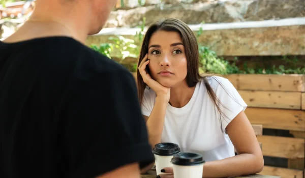 young-bored-woman-sitting-drinking-coffee-with-her-boyfriend young-bored-woman-sitting-drinking-coffee-with-her-boyfriend